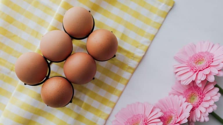 header image for blog post foods to increase amh levels - features picture of eggs and flowers on a table