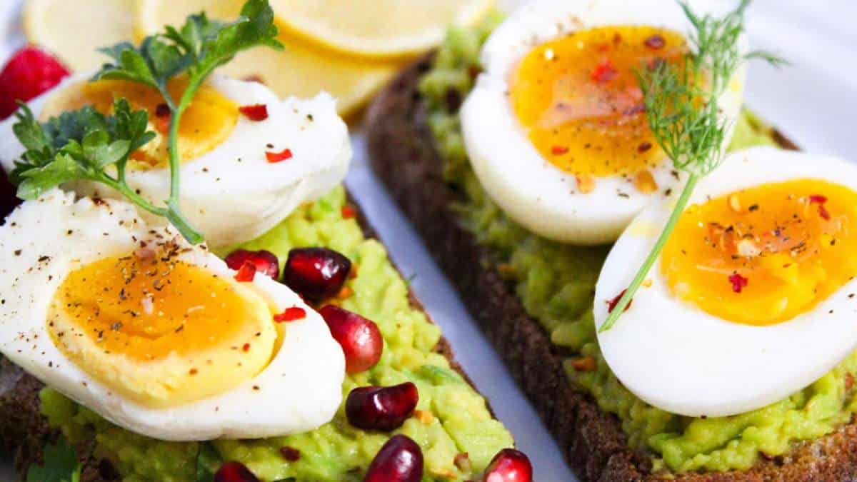 blog banner depicting eggs, pomegranate seeds, and avocado on whole grain toast for post titled 20 PCOS-friendly breakfasts
